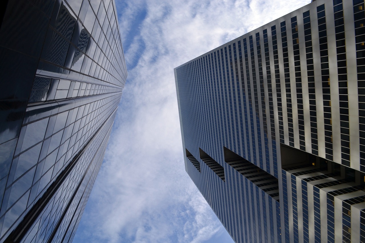 Zwei Bürohochhäuser aus Glas von unten gegen den blauen Himmel